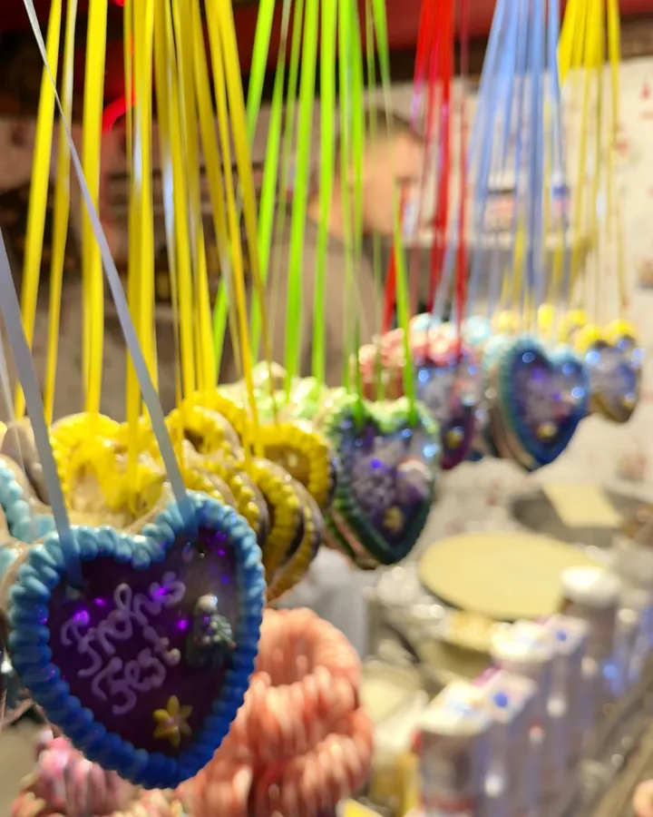 Bunt verzierte Lebkuchenherzen hängen dicht an dicht an einem Stand
