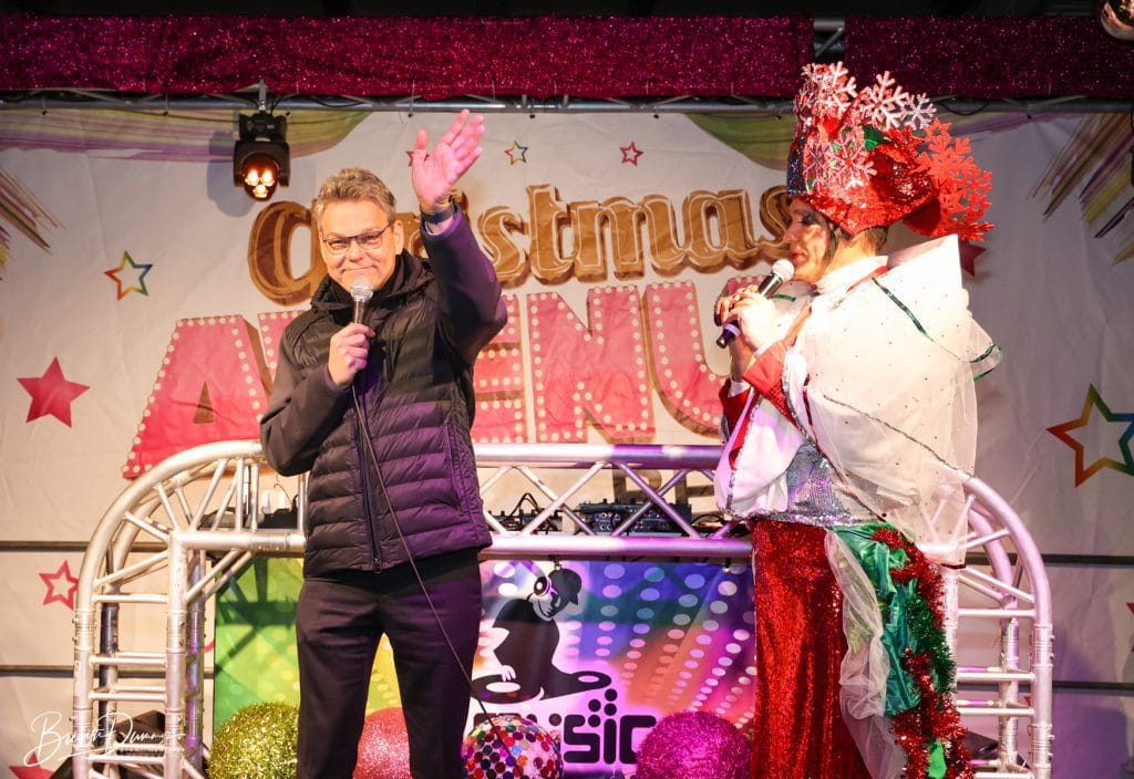 Politiker eröffnet die Christmas Avenue in Berlin gemeinsam mit einer Drag Queen auf der Bühne