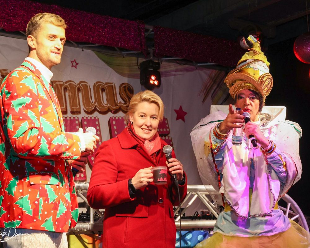 Berlins Bürgermeisterin Franziska Giffey auf der Bühne der Christmas Avenue mit Drag-Queen und Moderator