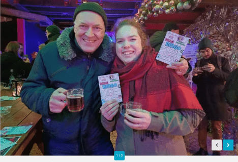 Drag Bingo auf der Christmas Avenue – Glühwein und Unterhaltung auf dem LGBTQIA* Weihnachtsmarkt in Berlin Besucher des LGBTQIA* Weihnachtsmarkts Christmas Avenue in Berlin beim Drag Bingo mit Glühwein.