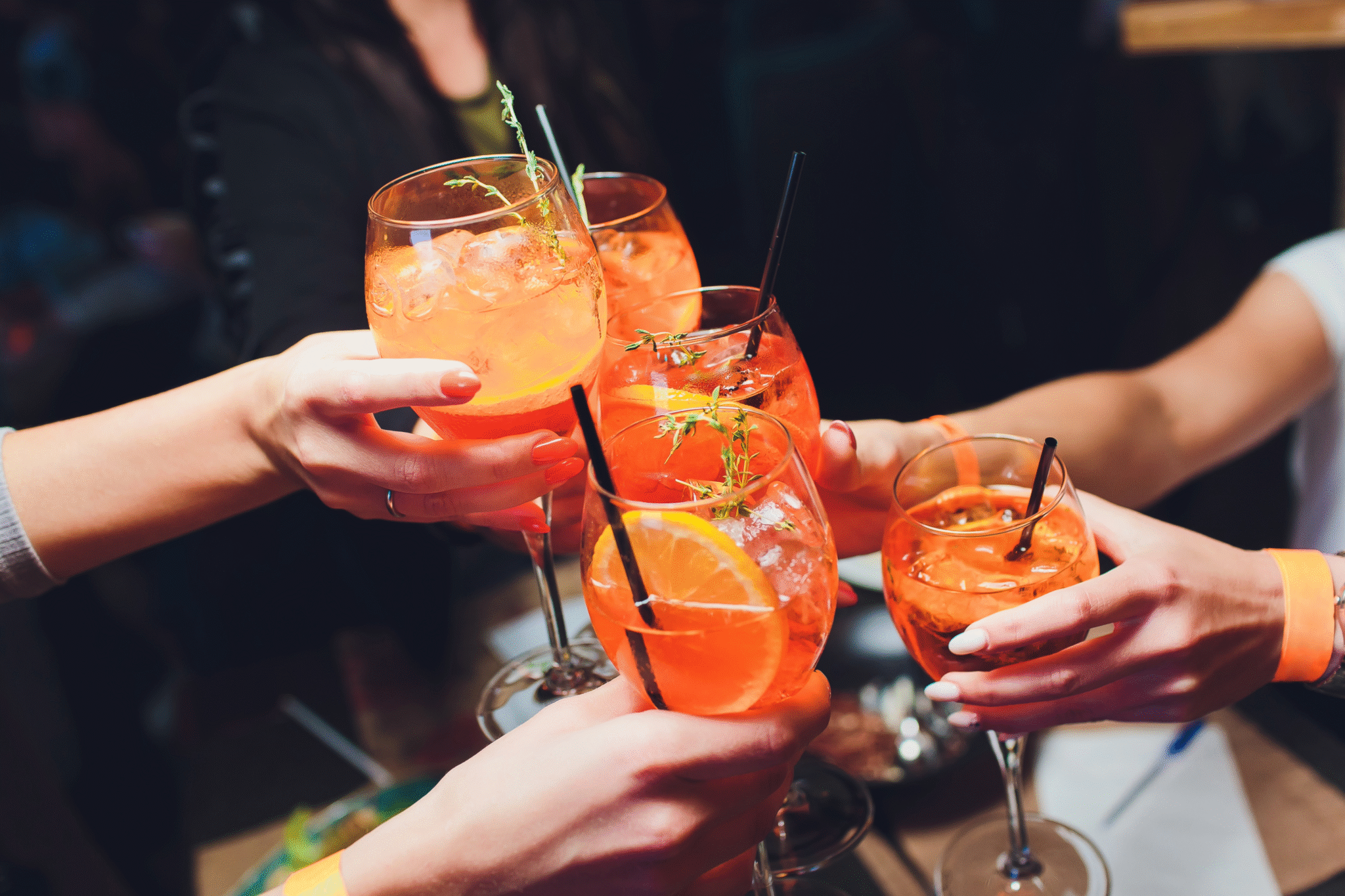 Freunde stoßen mit Aperol Spritz an bei der Holy Aperoli Happy Hour auf der Christmas Avenue Berlin.